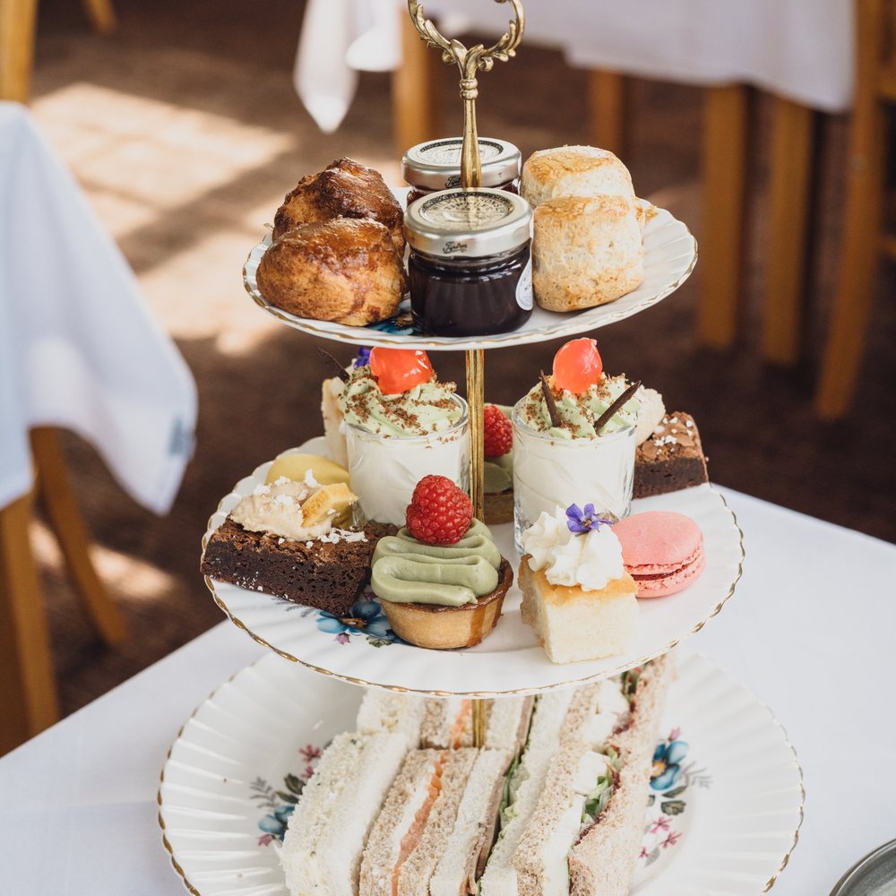 Afternoon tea on a three-tier stand: sandwiches, scones and cakes