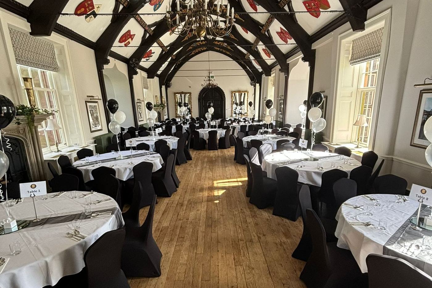 The Great Hall laid out with round tables for a party