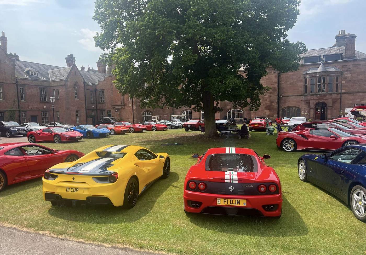 A sports car gathering on the lawn in front of the Abbey